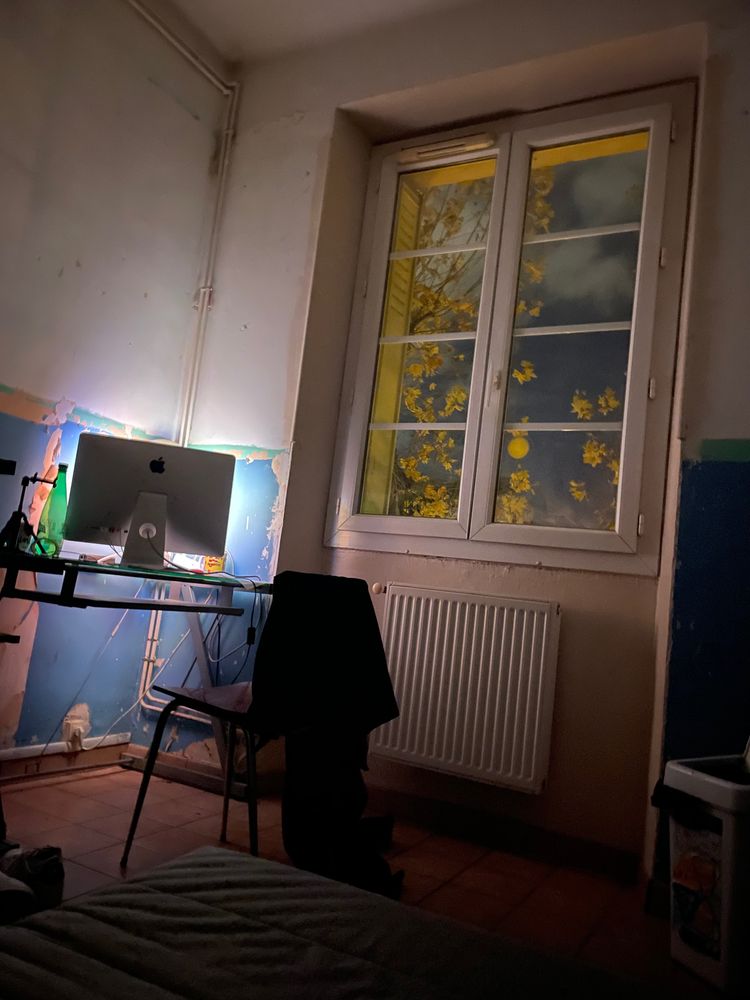 A room at night, a desk and a window on a yellow tree